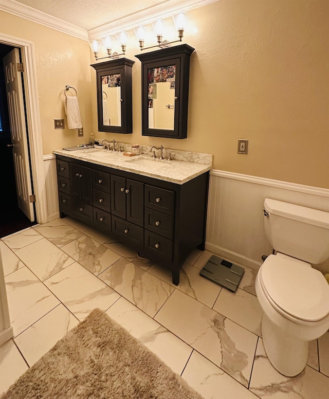 bathroom featuring vanity, toilet, crown molding, and a textured ceiling