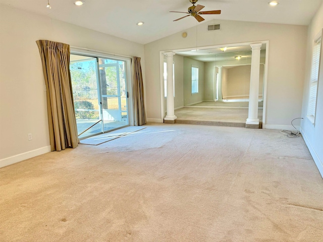 carpeted empty room featuring ceiling fan, ornate columns, and vaulted ceiling