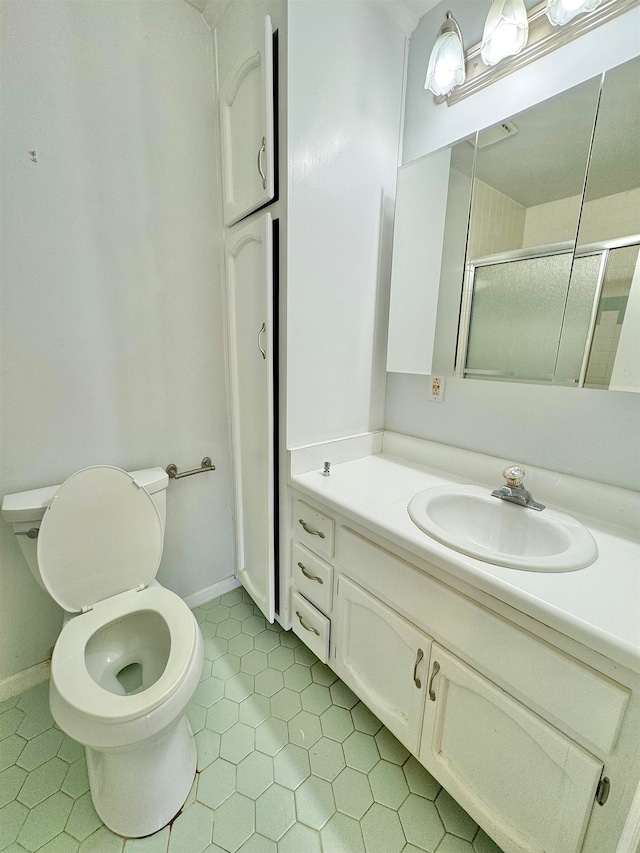 bathroom with tile patterned flooring, vanity, toilet, and an enclosed shower