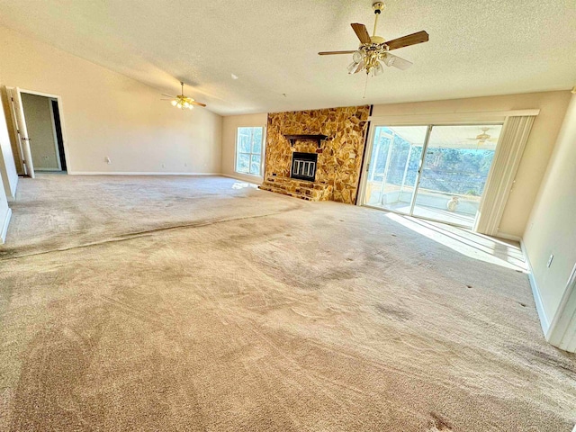 unfurnished living room with a fireplace, a healthy amount of sunlight, carpet flooring, and a textured ceiling