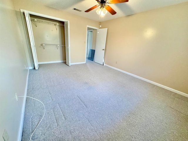 unfurnished bedroom with ceiling fan, a closet, and carpet