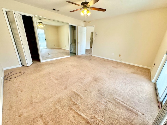 unfurnished bedroom featuring two closets, ceiling fan, and carpet floors