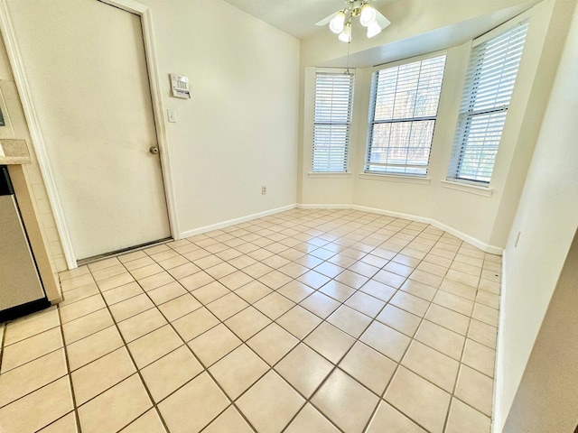 empty room with light tile patterned floors and ceiling fan