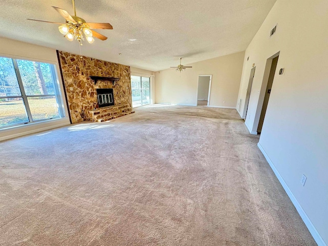 unfurnished living room with a textured ceiling, vaulted ceiling, a large fireplace, light colored carpet, and ceiling fan