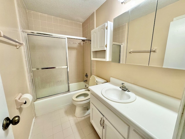 full bathroom with toilet, bath / shower combo with glass door, tile patterned flooring, a textured ceiling, and vanity