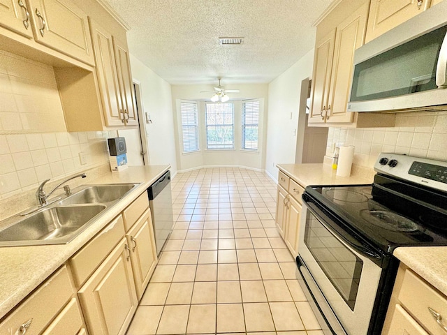 kitchen with light tile patterned floors, sink, backsplash, and appliances with stainless steel finishes