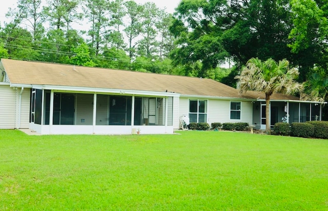 back of house with a lawn and a sunroom