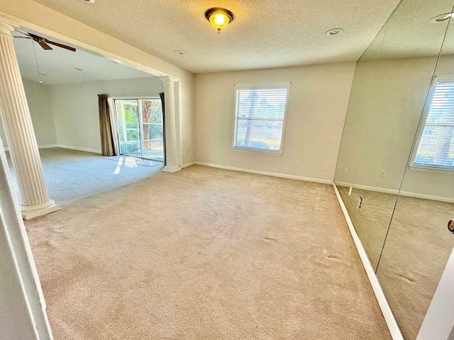 empty room featuring decorative columns and a wealth of natural light