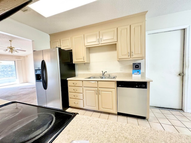 kitchen featuring light tile patterned flooring, a textured ceiling, sink, and appliances with stainless steel finishes