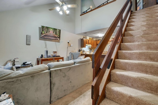 carpeted living room with high vaulted ceiling and ceiling fan