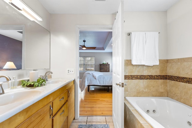 bathroom with vanity, a relaxing tiled tub, tile patterned floors, and ceiling fan