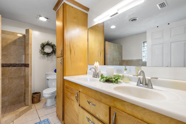 bathroom with tiled shower, tile patterned floors, toilet, and vanity