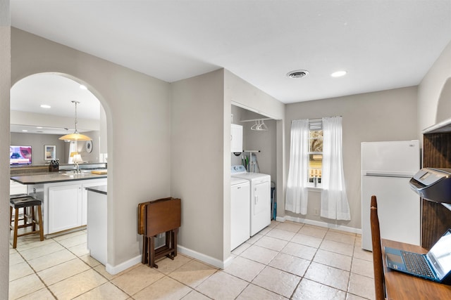 laundry room featuring sink, light tile patterned floors, and washer and clothes dryer