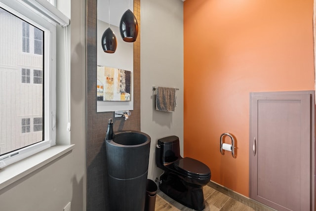 bathroom featuring wood-type flooring and toilet