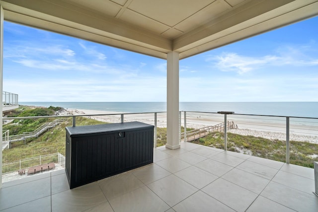 view of patio / terrace with a water view, a view of the beach, and a balcony