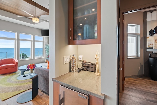 interior space featuring a water view, a healthy amount of sunlight, and wood-type flooring