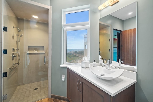 bathroom with a shower with shower door, vanity, and wood-type flooring