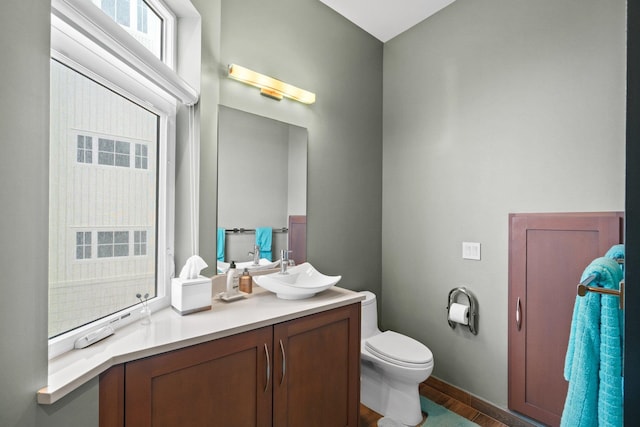 bathroom featuring wood-type flooring, toilet, and vanity