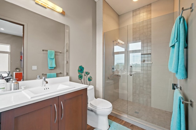 bathroom with hardwood / wood-style floors, walk in shower, vanity, and toilet