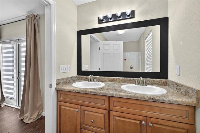 3974 Paeonia Ct, Tallahassee, FL 32305 - bathroom with wood finished floors, double vanity, a textured wall, and a shower