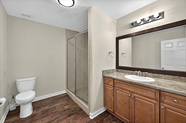 3974 Paeonia Ct, Tallahassee, FL 32305 - bathroom with wood finished floors, a stall shower, toilet, vanity, and baseboards