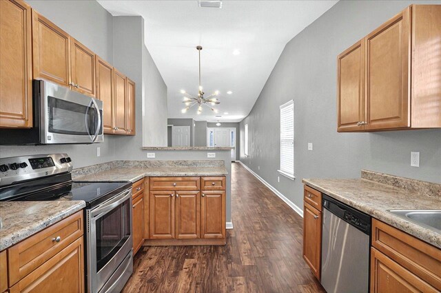3974 Paeonia Ct, Tallahassee, FL 32305 - kitchen with stainless steel appliances, lofted ceiling, dark wood-style flooring, a peninsula, and a chandelier