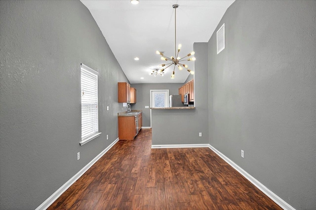 3974 Paeonia Ct, Tallahassee, FL 32305 - kitchen with brown cabinets, a chandelier, refrigerator, a sink, and baseboards