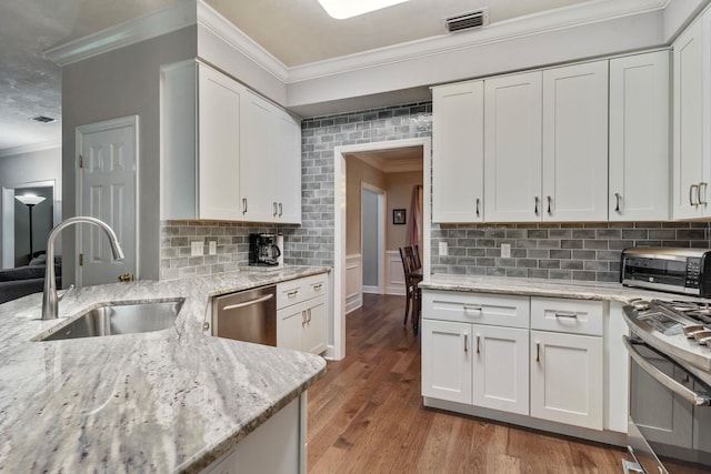 438 Meadow Ridge Dr, Tallahassee, FL 32312 - kitchen featuring appliances with stainless steel finishes, ornamental molding, white cabinetry, and wood finished floors