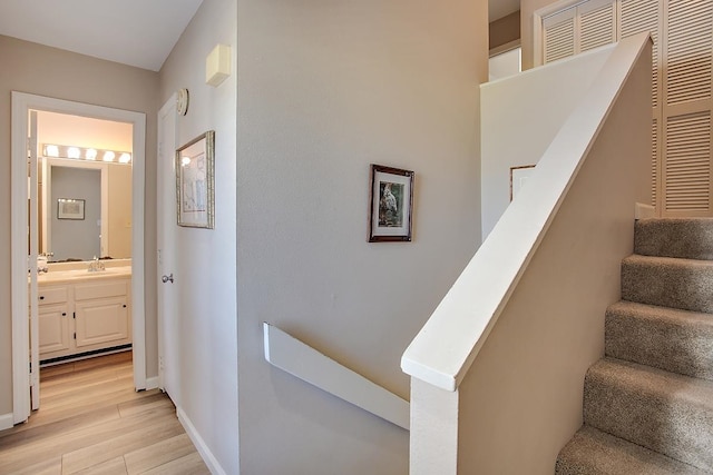 staircase with wood-type flooring and sink