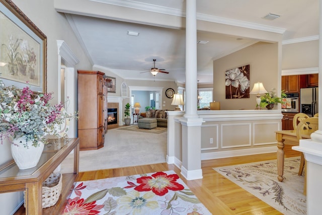 2605 Antietam Trl, Tallahassee, FL 32312 - foyer entrance with decorative columns, light wood-type flooring, ceiling fan, a tiled fireplace, and ornamental molding