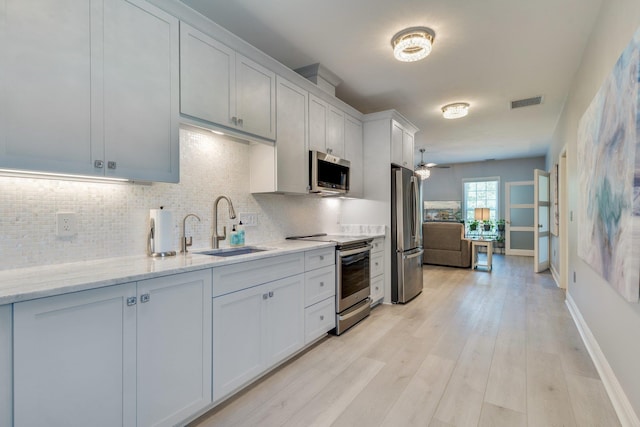 2605 Antietam Trl, Tallahassee, FL 32312 - kitchen featuring appliances with stainless steel finishes, a sink, tasteful backsplash, and light wood-style floors