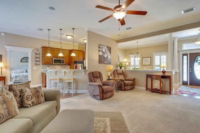 2605 Antietam Trl, Tallahassee, FL 32312 - living room with crown molding, a ceiling fan, baseboards, light carpet, and ornate columns