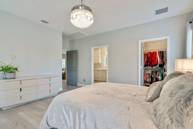 2605 Antietam Trl, Tallahassee, FL 32312 - bedroom featuring a walk in closet, attic access, light wood finished floors, a chandelier, and ensuite bath