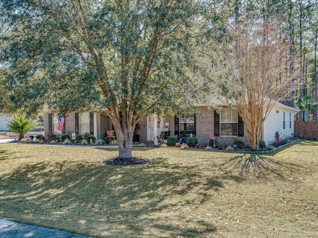 view of property hidden behind natural elements featuring a front lawn