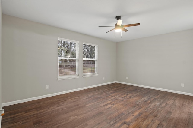 empty room featuring dark wood-style floors, baseboards, and ceiling fan