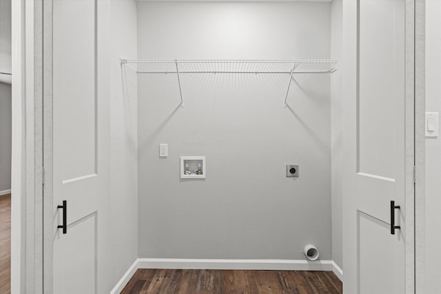 laundry area with laundry area, electric dryer hookup, dark wood-type flooring, and baseboards