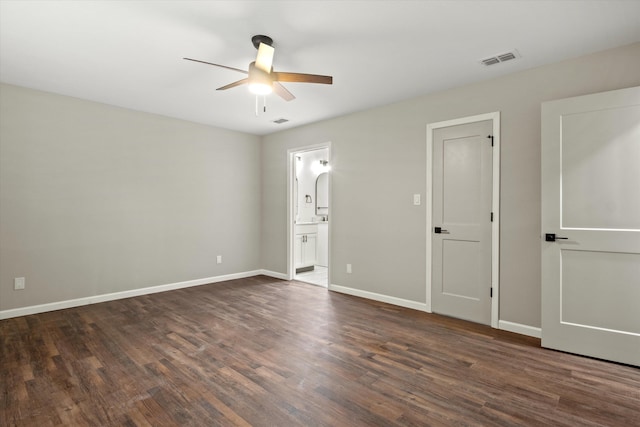 unfurnished bedroom with visible vents, baseboards, and dark wood-type flooring