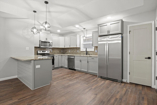 kitchen with a sink, tasteful backsplash, appliances with stainless steel finishes, and a peninsula