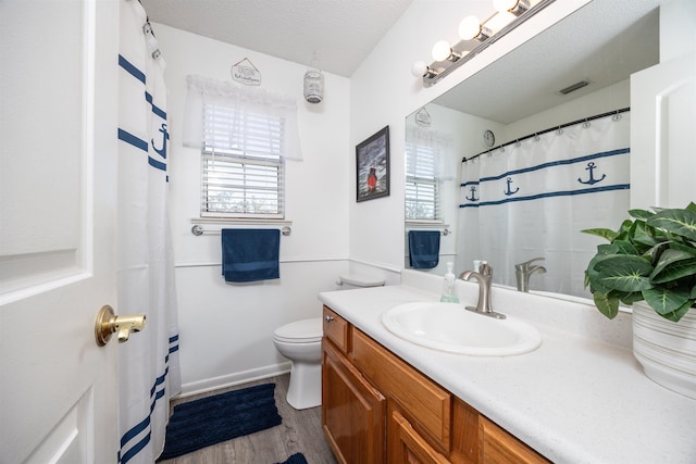 bathroom featuring a textured ceiling, vanity, hardwood / wood-style flooring, and toilet