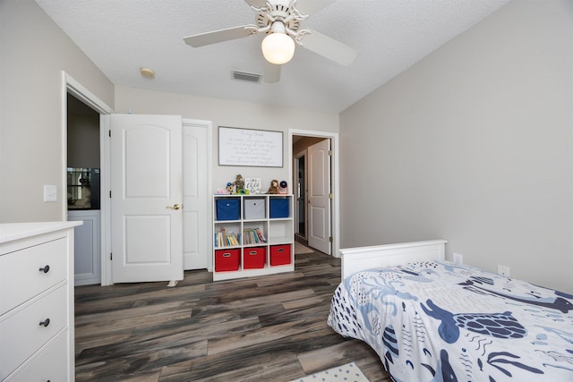 bedroom featuring ceiling fan, dark wood-type flooring, and a textured ceiling