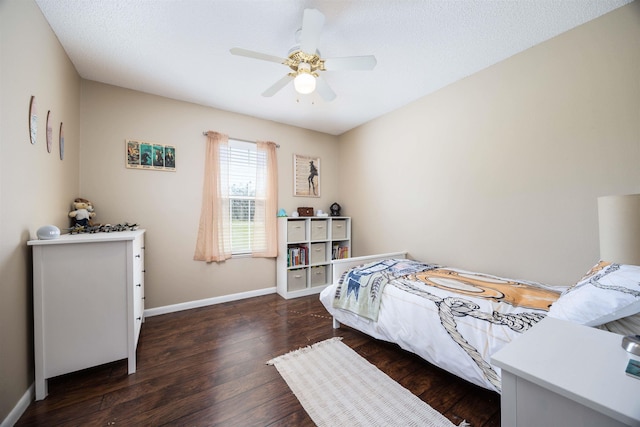 bedroom featuring a textured ceiling, ceiling fan, and dark wood-type flooring