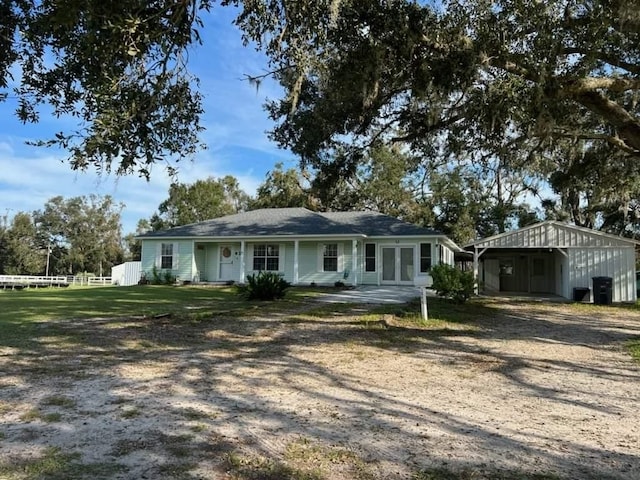 ranch-style house with french doors, fence, and dirt driveway