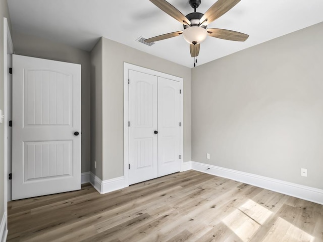 unfurnished bedroom featuring ceiling fan, light hardwood / wood-style flooring, and a closet