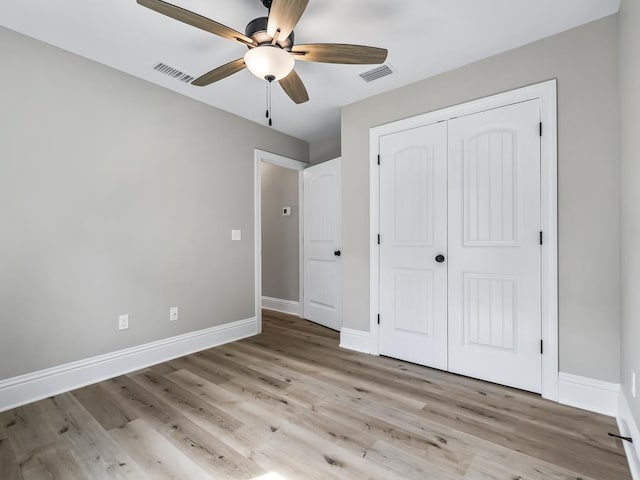 unfurnished bedroom featuring ceiling fan, a closet, and light wood-type flooring