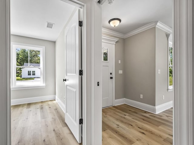 foyer entrance featuring ornamental molding and light hardwood / wood-style flooring