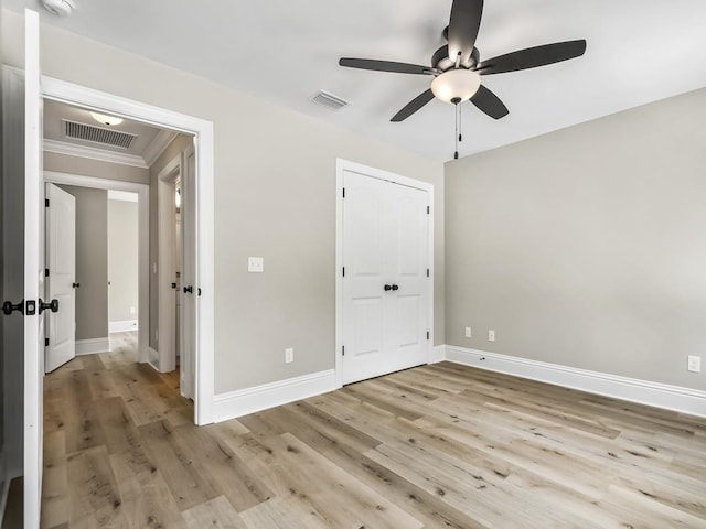 unfurnished bedroom featuring ceiling fan, crown molding, and light hardwood / wood-style flooring