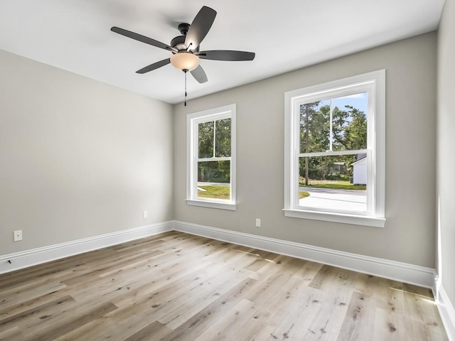 spare room with plenty of natural light, ceiling fan, and light hardwood / wood-style flooring