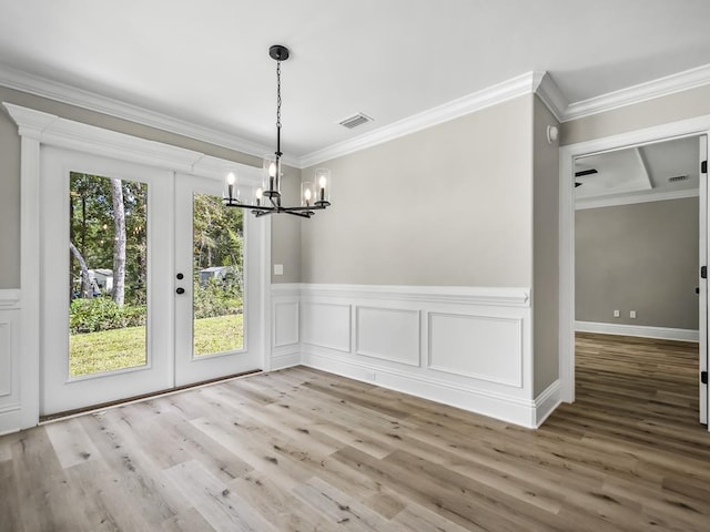 unfurnished dining area featuring a wealth of natural light, crown molding, and french doors