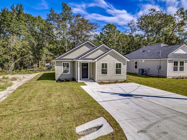 ranch-style house with central air condition unit and a front yard