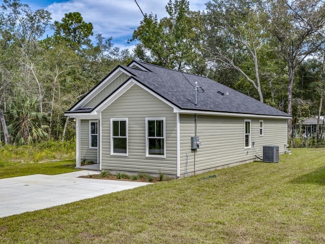 back of house featuring central AC unit, a patio area, and a lawn